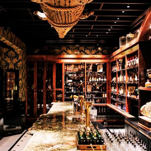 Bar Interior with Shelves of Alcohol and Bartender Materials